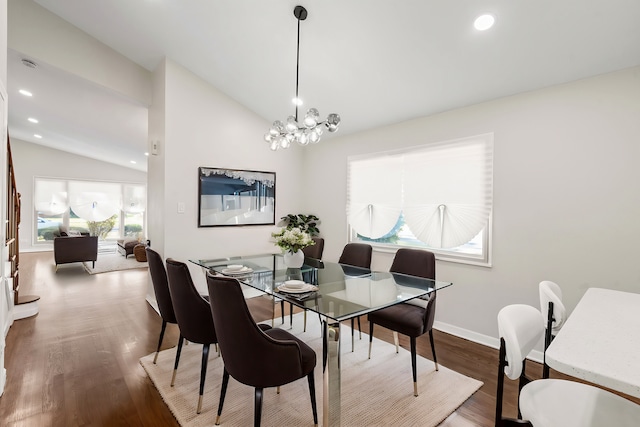 dining space featuring vaulted ceiling, dark hardwood / wood-style flooring, and a chandelier