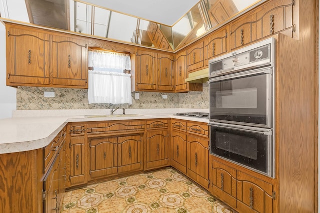 6102 W 64th St, Chicago, IL 60638 - kitchen with decorative backsplash, multiple ovens, brown cabinetry, a sink, and gas cooktop