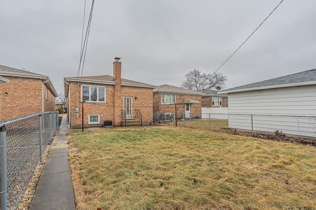 6102 W 64th St, Chicago, IL 60638 - back of house featuring brick siding, a lawn, a chimney, and a fenced backyard