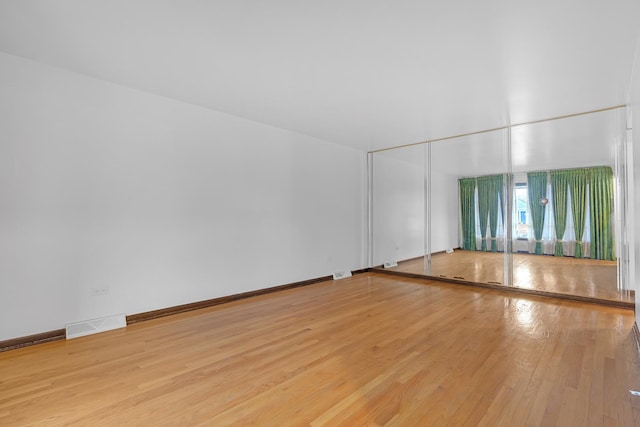 6102 W 64th St, Chicago, IL 60638 - empty room with wood finished floors, visible vents, and baseboards