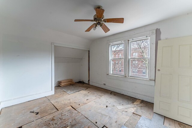 unfurnished bedroom featuring ceiling fan, vaulted ceiling, and a closet