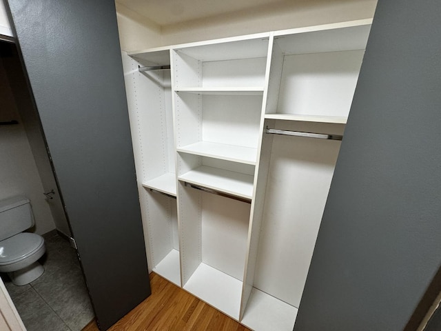 walk in closet with dark wood-type flooring