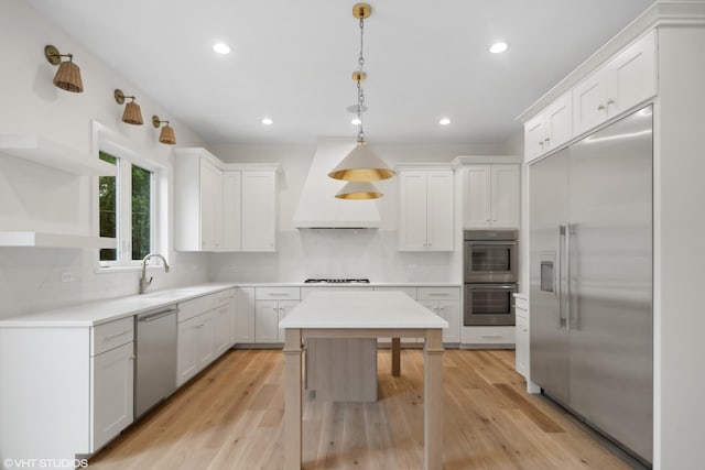 kitchen with stainless steel appliances, a sink, light wood-type flooring, backsplash, and custom exhaust hood