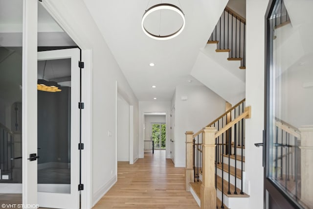 foyer featuring recessed lighting, baseboards, light wood finished floors, and stairs