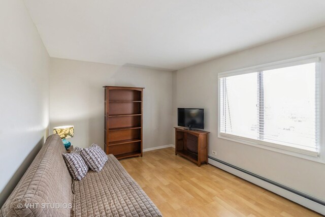 living room with baseboard heating and light wood-type flooring