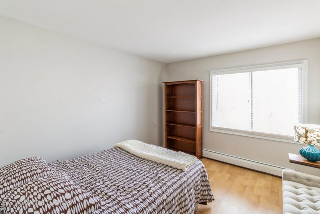 bedroom featuring a baseboard radiator and light wood-type flooring