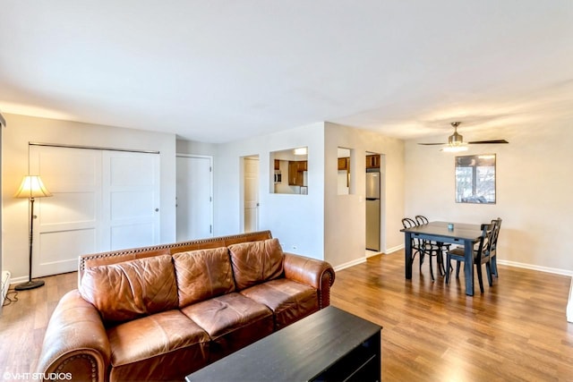 living room featuring ceiling fan and hardwood / wood-style floors