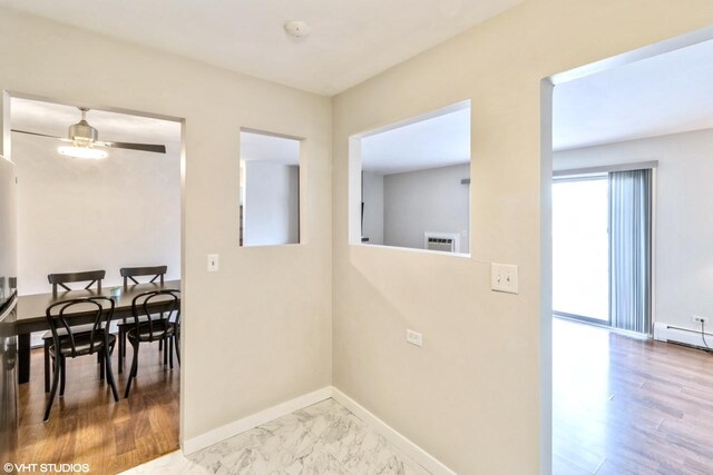 laundry area featuring a wall unit AC, ceiling fan, and baseboard heating