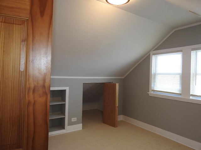 bonus room featuring lofted ceiling, light carpet, and built in features