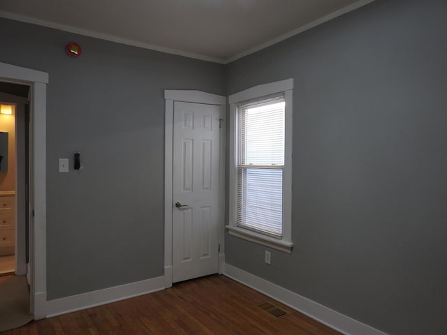 unfurnished bedroom featuring crown molding and dark hardwood / wood-style floors