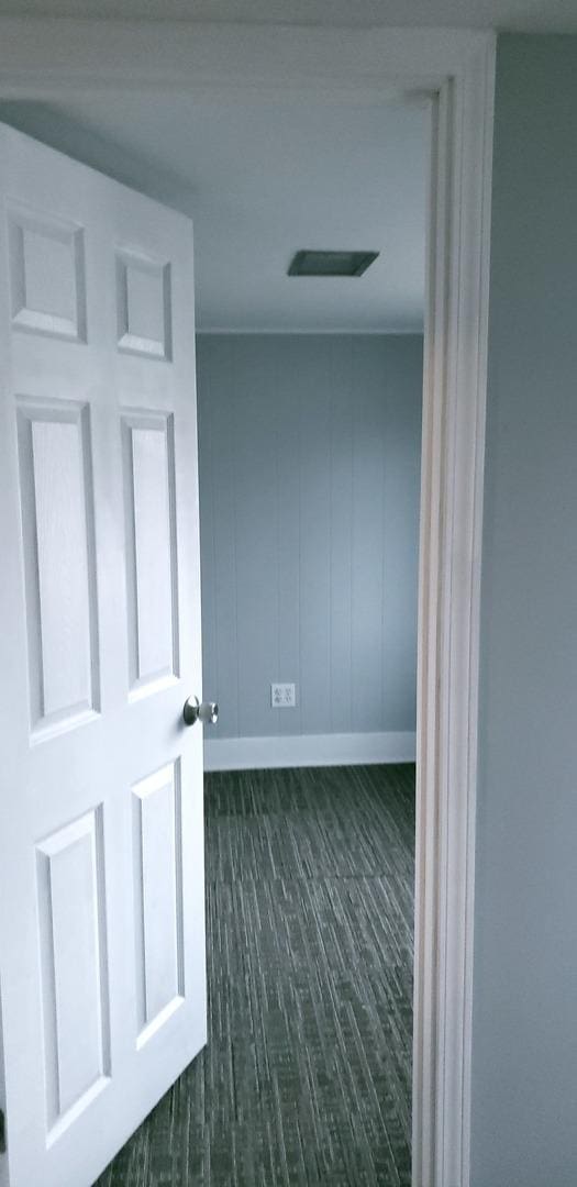 corridor with dark hardwood / wood-style flooring