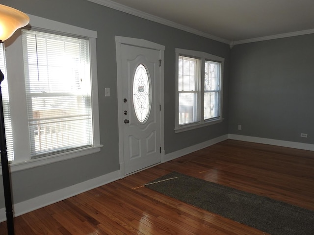 entrance foyer featuring dark wood-type flooring, ornamental molding, and plenty of natural light