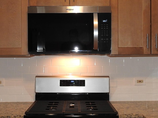 details with light stone counters, stainless steel appliances, and tasteful backsplash