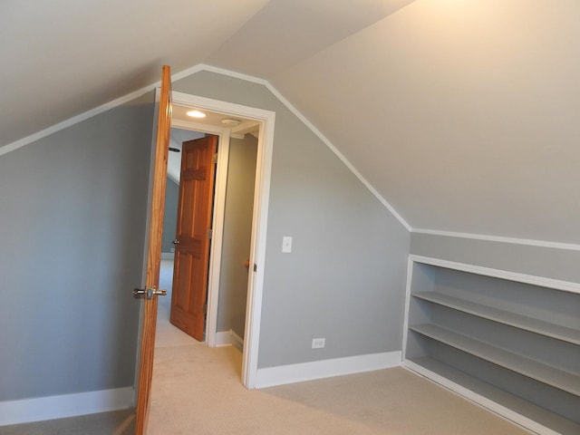 additional living space featuring lofted ceiling and light carpet