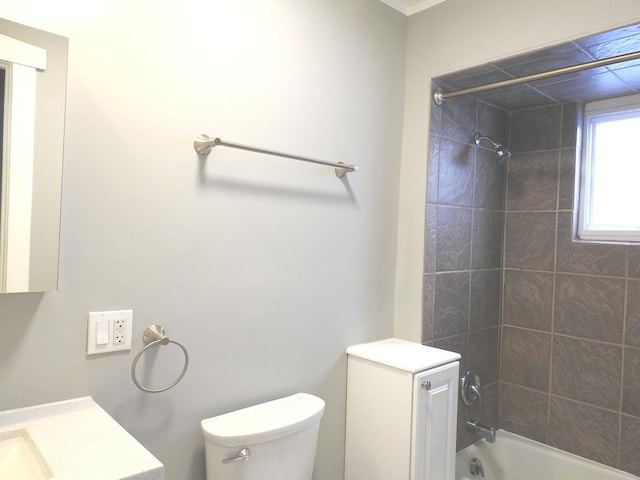 full bathroom featuring tiled shower / bath, vanity, and toilet