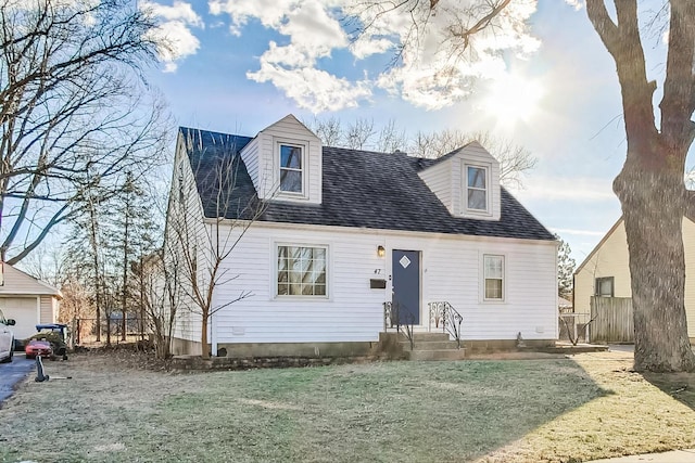 cape cod home featuring a front lawn