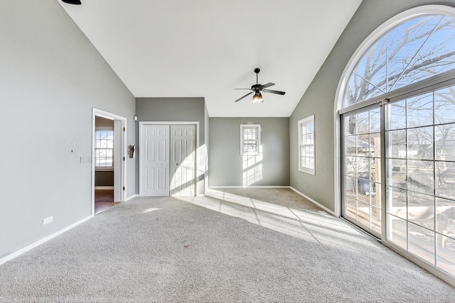 interior space featuring high vaulted ceiling, light colored carpet, and ceiling fan