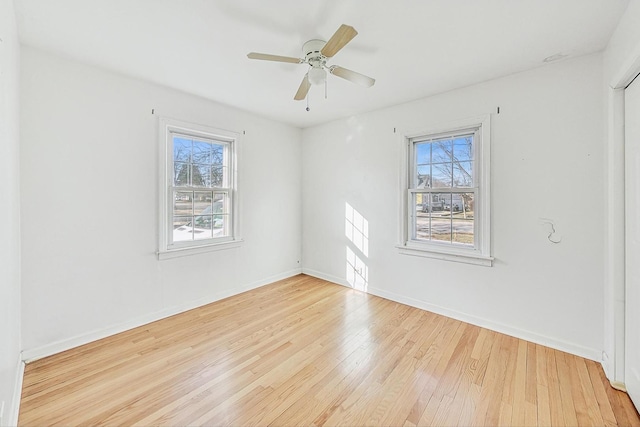 spare room featuring ceiling fan, a healthy amount of sunlight, and light hardwood / wood-style floors