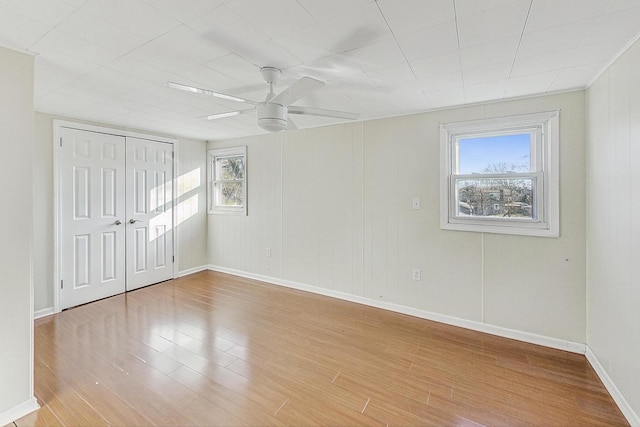 unfurnished bedroom featuring light hardwood / wood-style flooring, a closet, and ceiling fan