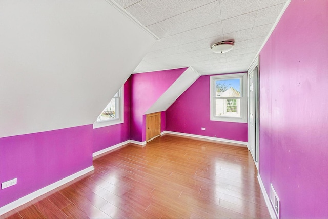 additional living space featuring hardwood / wood-style flooring and lofted ceiling