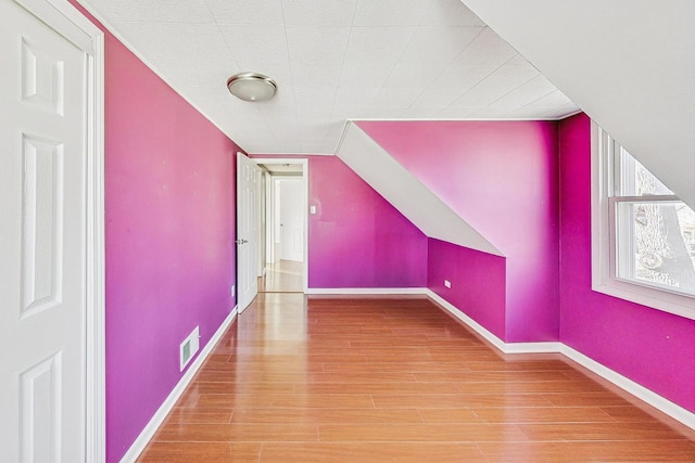 additional living space featuring lofted ceiling and hardwood / wood-style floors