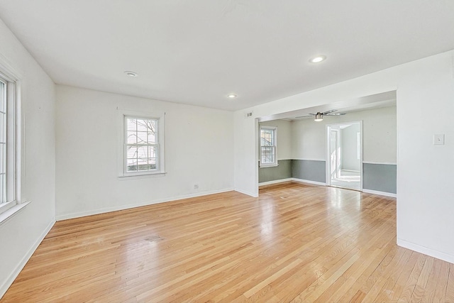 spare room with plenty of natural light, ceiling fan, and light wood-type flooring