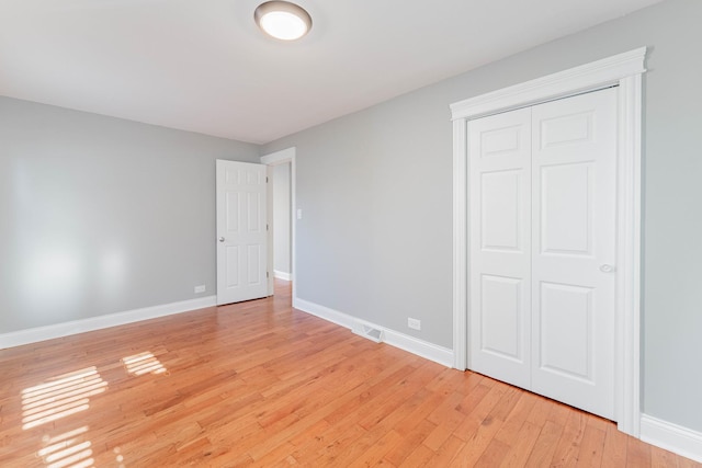 unfurnished bedroom featuring a closet and light wood-type flooring