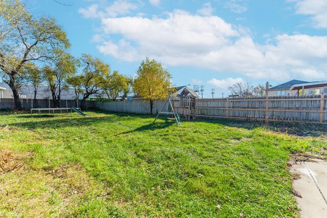 view of yard featuring a playground and a trampoline