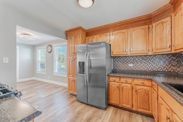 kitchen with stainless steel refrigerator with ice dispenser, sink, decorative backsplash, and light hardwood / wood-style flooring