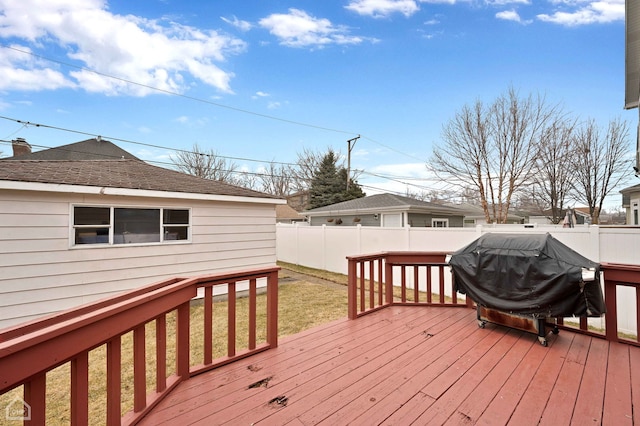 wooden terrace featuring a grill, a fenced backyard, and a yard