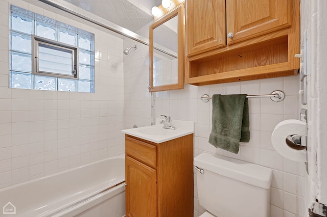 bathroom featuring toilet, tasteful backsplash, washtub / shower combination, and tile walls