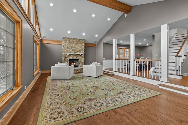 living room with hardwood / wood-style flooring, high vaulted ceiling, a fireplace, and beamed ceiling