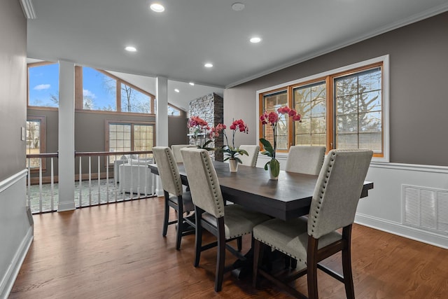 dining space featuring hardwood / wood-style flooring, ornamental molding, and vaulted ceiling