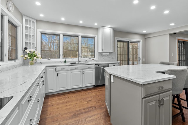 kitchen featuring a center island, a kitchen breakfast bar, dishwasher, and white cabinets