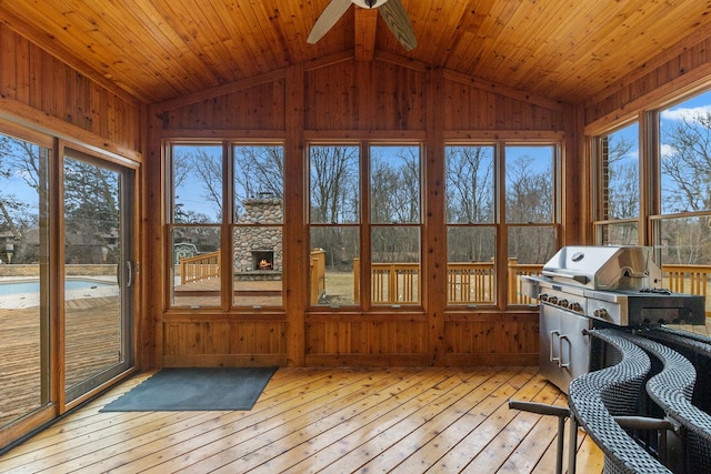 unfurnished sunroom featuring ceiling fan, lofted ceiling, and wood ceiling