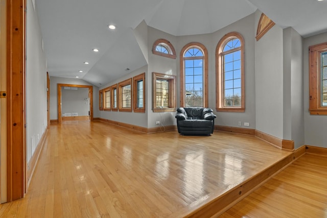 unfurnished room featuring vaulted ceiling and light hardwood / wood-style floors