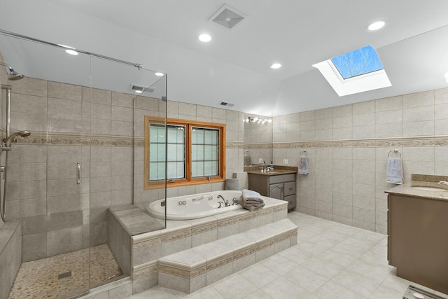 bathroom featuring tile walls, vanity, tile patterned flooring, and lofted ceiling