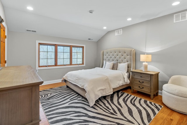 bedroom with vaulted ceiling and light wood-type flooring