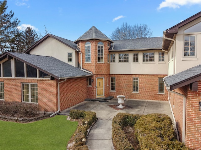 exterior space featuring a front lawn and a patio