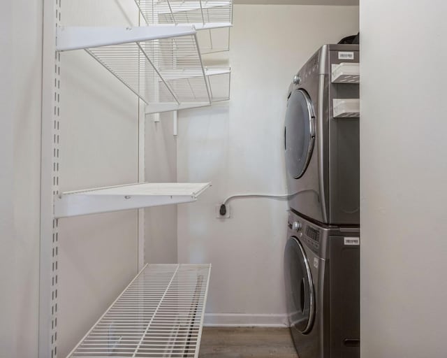 washroom featuring hardwood / wood-style flooring and stacked washer / drying machine