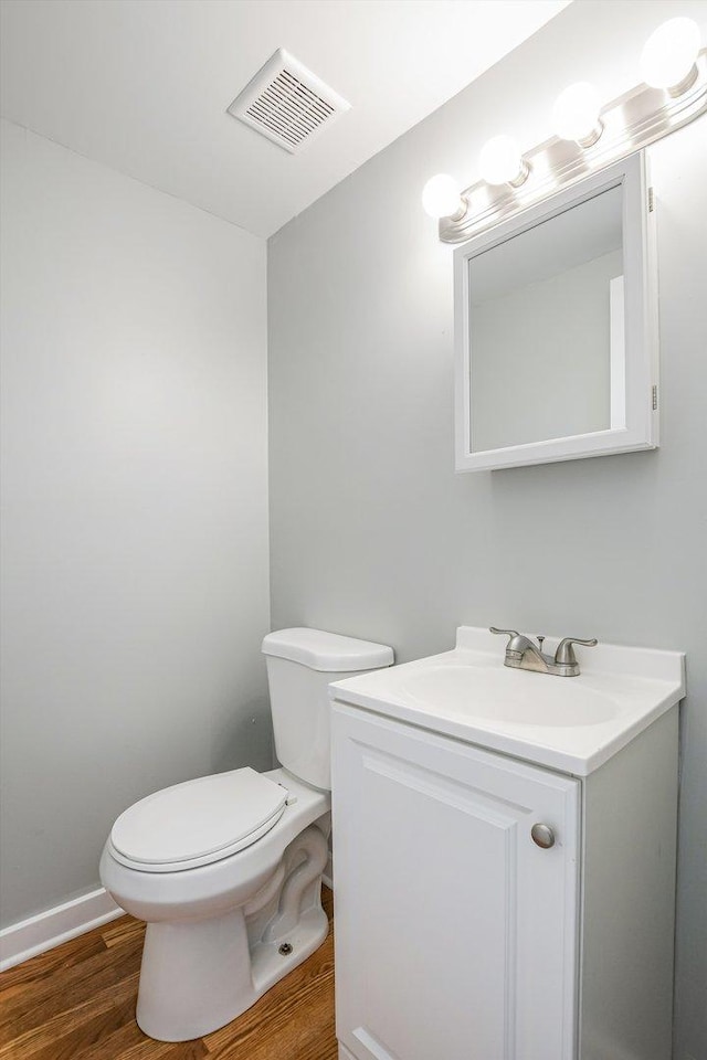 bathroom featuring hardwood / wood-style flooring, vanity, and toilet