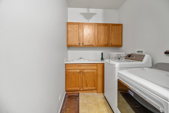 laundry room featuring separate washer and dryer, sink, and cabinets