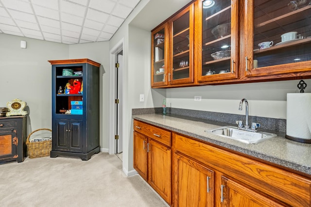 bar with a paneled ceiling, sink, and light colored carpet