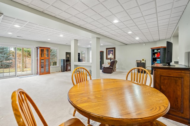 dining room with light carpet and a drop ceiling