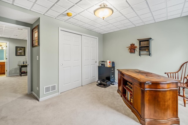 home office featuring light carpet and a paneled ceiling