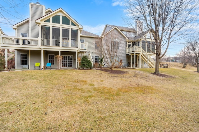 back of house with a sunroom and a yard