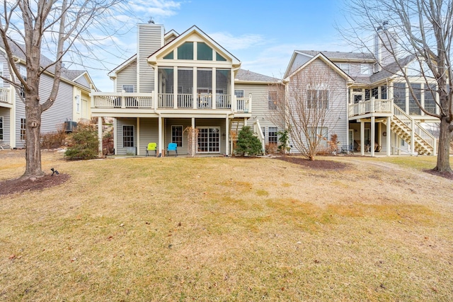 back of house featuring a sunroom and a lawn