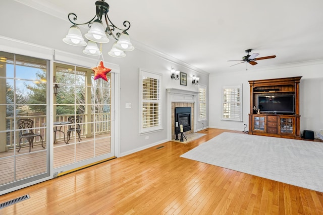 unfurnished living room with crown molding, wood-type flooring, and a tile fireplace