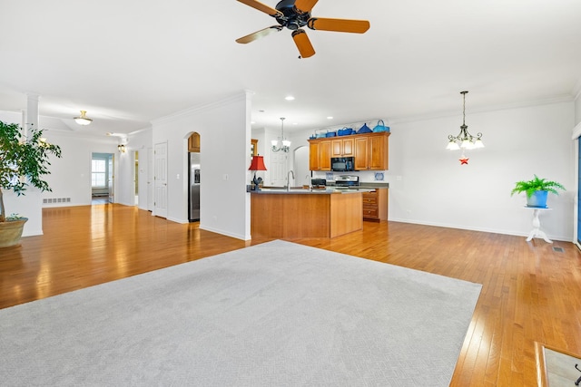 kitchen featuring crown molding, decorative light fixtures, light hardwood / wood-style flooring, stainless steel appliances, and ceiling fan with notable chandelier