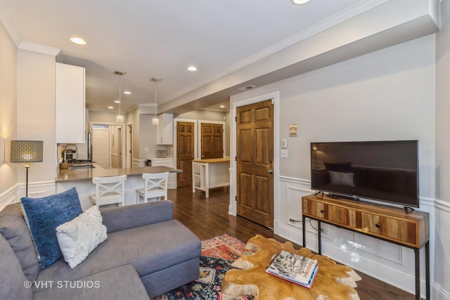 living room featuring sink, dark hardwood / wood-style flooring, and ornamental molding